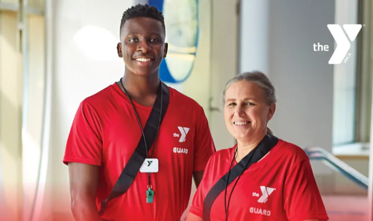 two YMCA lifeguards holding flotation devices.
