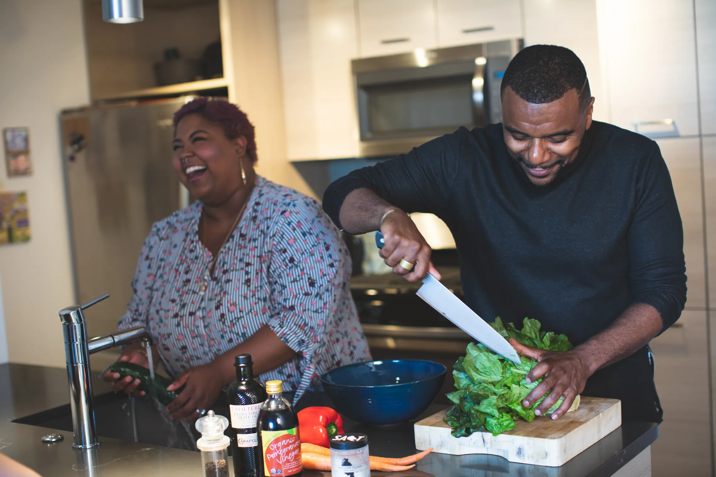 A mother and son laughing while cooking at home. 