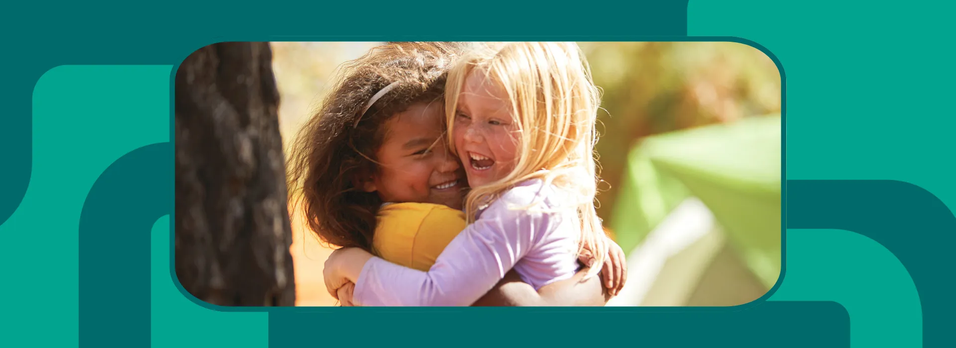 two small children hugging each other and smiling.